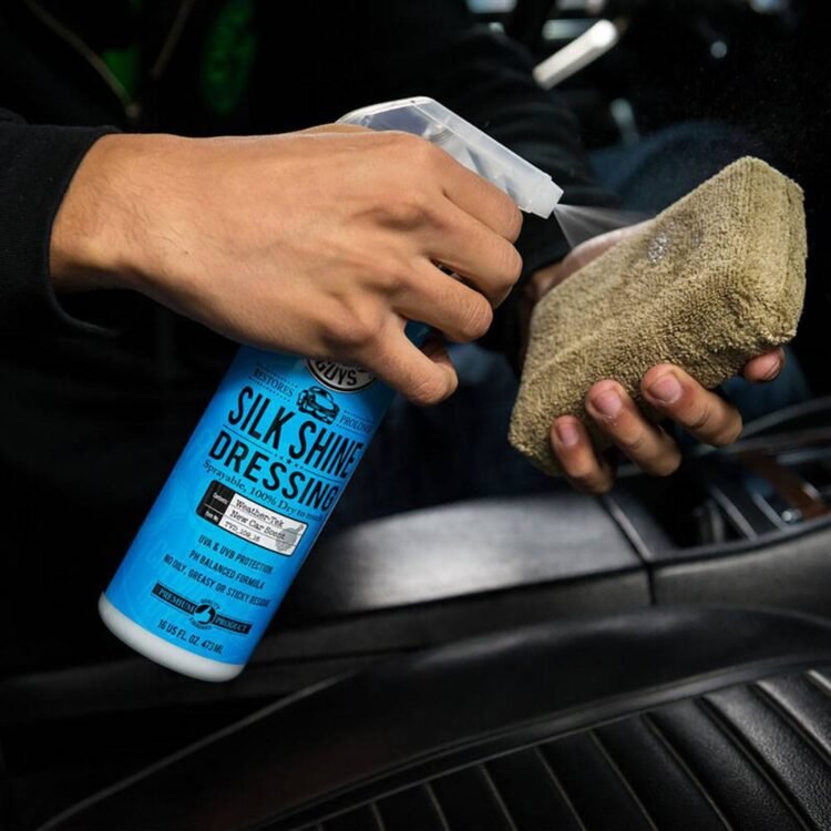 Muškarac prska Silk Shine sredstvo na braon mikrofiber aplikator unutar automobila.